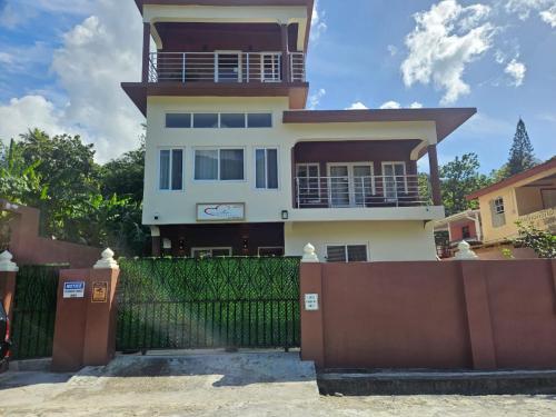 a house with a fence in front of it at Agape Suites-Room 2-Ground Floor in Soufrière