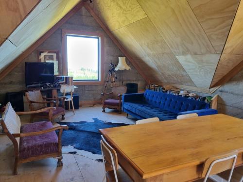 un salon avec un canapé bleu et une table dans l'établissement Pikikirunga House, Takaka Hill, à Upper Takaka