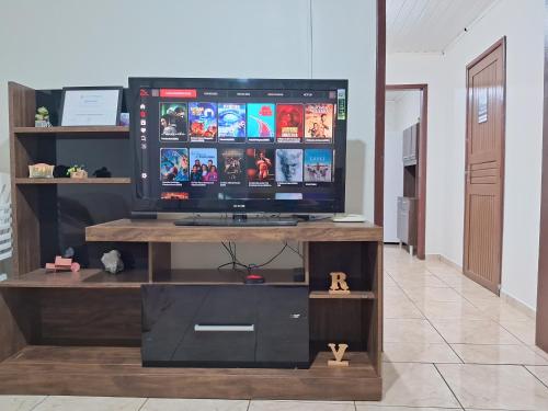 Un televisor en un centro de entretenimiento de madera en una habitación. en Quartos Morumbi, en Foz do Iguaçu