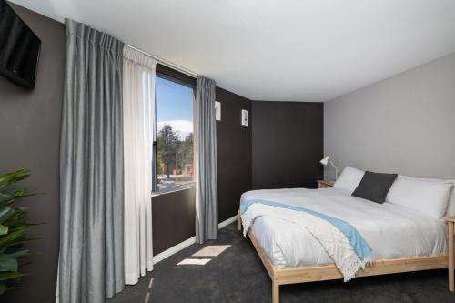 a bedroom with a bed and a large window at Griffin 165 in Kingston 