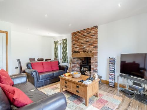 a living room with a couch and a fireplace at The Paddocks in Lowestoft