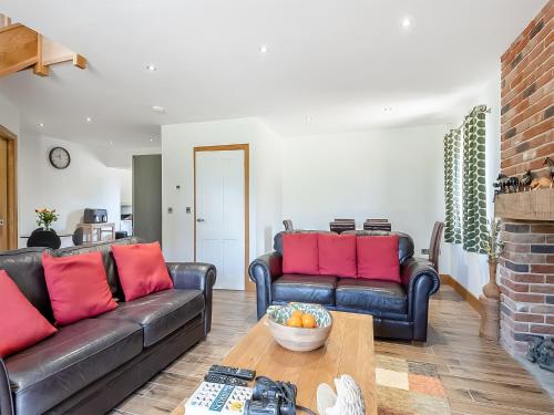 a living room with two leather couches and a table at The Paddocks in Lowestoft