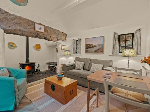 a living room with a couch and a table and a fireplace at Garth Yr Hebog in Porthmadog