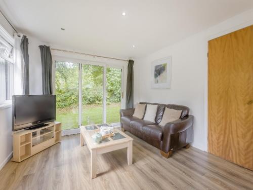 a living room with a leather couch and a tv at Keepers Wood - W43109 in Bradworthy