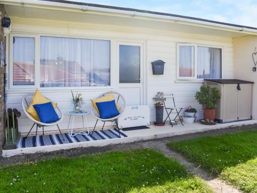 a patio with two chairs and a table at Escape To The Chalet in Pakefield