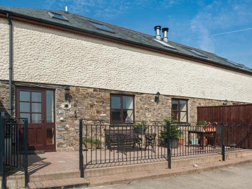 a brick building with a fence in front of it at The Old Shippen - Uk48328 in Lifton