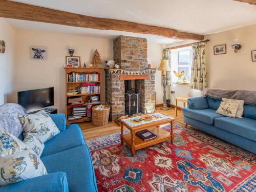 a living room with a blue couch and a fireplace at The Old Shippen - Uk48328 in Lifton