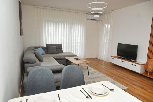 a living room with a couch and a tv at Sweet Dreams Apartment in Pristina
