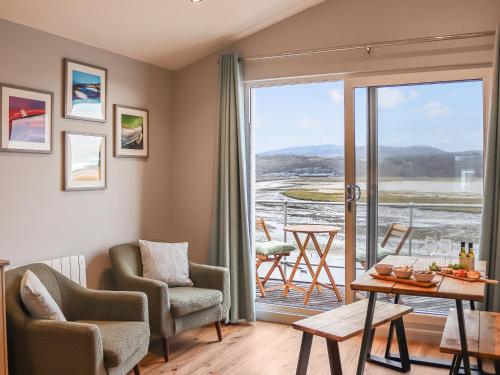 South Snowdon Wharf في بورثمادوج: غرفة معيشة مع طاولة وكراسي وشرفة
