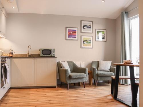 a kitchen with two chairs and a counter and a table at South Snowdon Wharf in Porthmadog