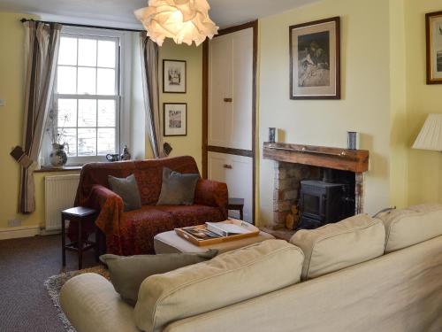 a living room with a couch and a fireplace at Woodburn Cottage in Soutergate