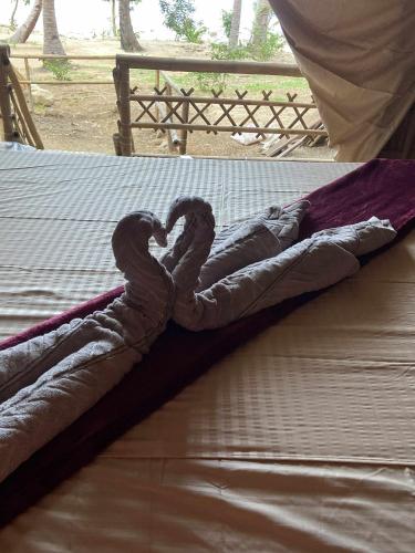 a baby doll laying on top of a bed at MORE Beach in El Nido
