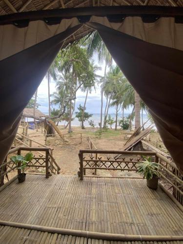 a tent with a table and benches on a beach at MORE Beach in El Nido