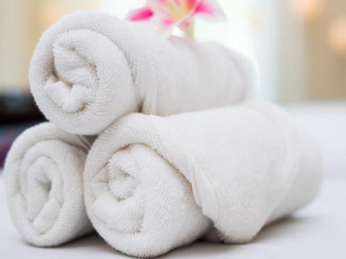 una pila de toallas blancas sentadas en una mesa en Hotel Sunshine At Delhi Airport, en Dwarka, Nueva Delhi