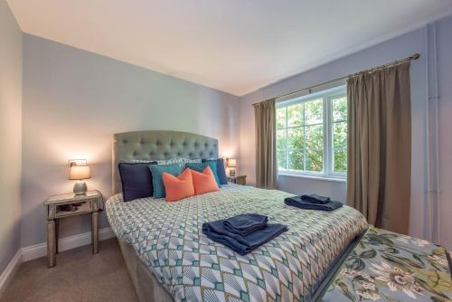 a bedroom with a bed with blue and orange pillows at Eiddew-Y-Ffynnon in Llanfyrnach