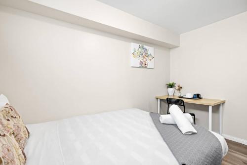 a white bedroom with a bed and a desk at Relaxed Private Double Room in Carramar - Close to Station - Shared Bathroom in Villawood
