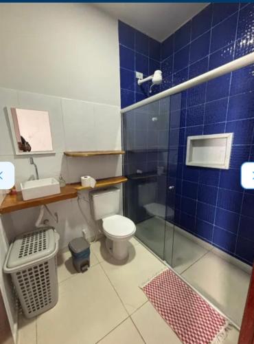 a blue tiled bathroom with a toilet and a shower at casa sol e mar 01 in Paripueira