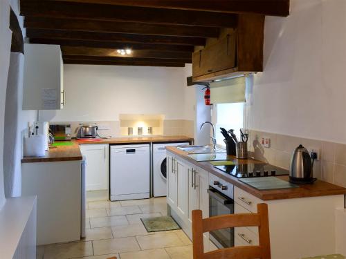 eine Küche mit weißen Schränken und einem Herd mit Backofen in der Unterkunft Nan-Tis in St. Issey