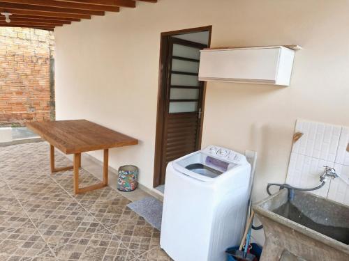 a kitchen with a washing machine and a table at House - Cantinho de Jacaré in Jacarèzinho