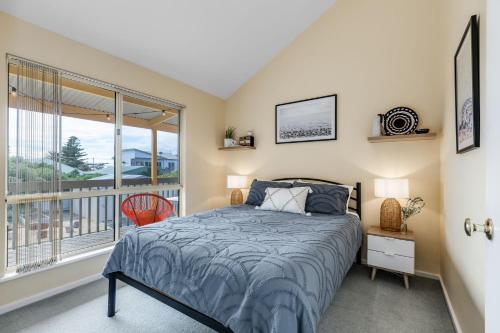 a bedroom with a bed and a balcony at Sunnys Beachhouse - 70 Hargreaves Rd, Middleton in Middleton
