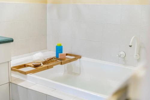 a bathroom with a bath tub with a bottle of soap at Sunnys Beachhouse - 70 Hargreaves Rd, Middleton in Middleton