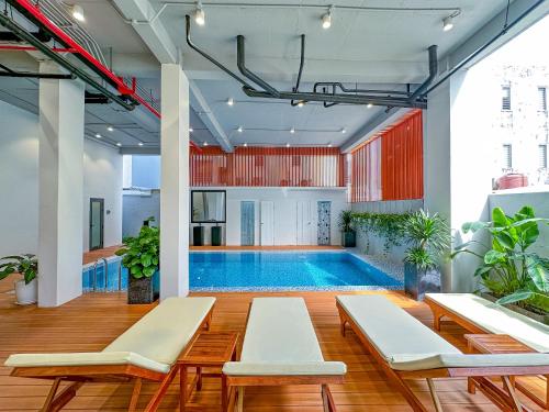 una piscina in una stanza con sedie e una piscina di C-Hotel a Sihanoukville