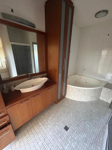 a bathroom with a tub and a sink and a mirror at Comfort Home For You in Perth