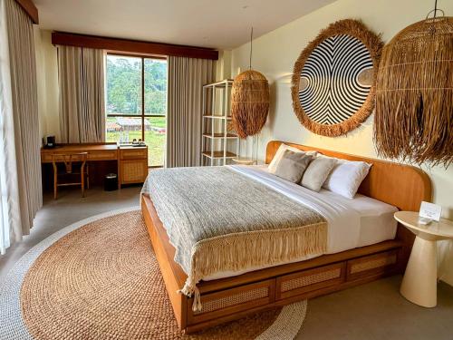 een slaapkamer met een bed en een bureau erin bij Santai Toraja in Rantepao