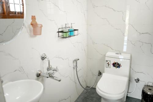 a bathroom with a toilet and a sink at Serenity heights cosy 2BHK in Jāmb
