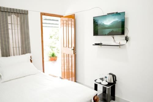 a bedroom with a bed and a tv on a wall at Serenity heights cosy 2BHK in Jāmb