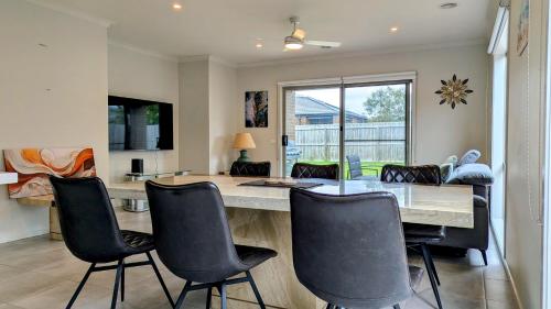 a dining room with a table and chairs at Comfy & spacious home near Bellarine Rail Trail in Curlewis