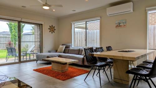 una sala de estar con un sofá y una mesa en Comfy & spacious home near Bellarine Rail Trail, en Curlewis