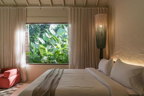 a bedroom with a large bed and a window at Arde La Selva in Santa Fe de Antioquia