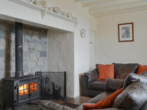 a living room with a fireplace and a couch at Penrhyn Mawr - Hw7642 in Aberdaron