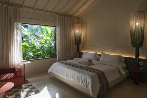 a bedroom with a large bed and a large window at Arde La Selva in Santa Fe de Antioquia