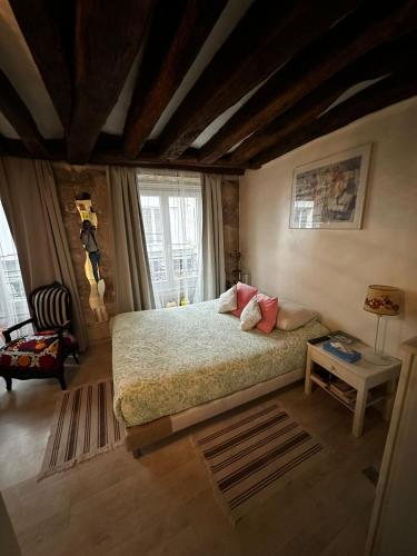 a bedroom with a large bed and a table at Cosy studio Montorgueil paris centre in Paris