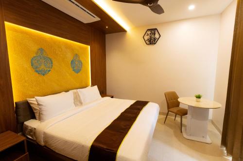 um quarto de hotel com uma cama e uma mesa em Kaizen Residency Trichy em Tiruchchirappalli