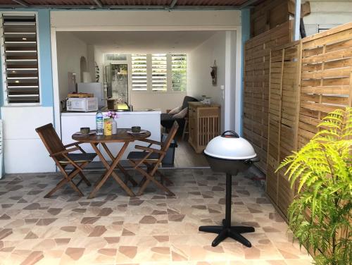 レ・トロワ・イレにあるGrand F2 luxe 3 mn plage avec jardin pointe du boutのパティオ(テーブル、椅子付)、