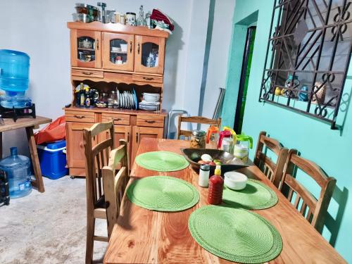a dining room with a wooden table with green plates on it at Mi Casita en Sivar in Apopa