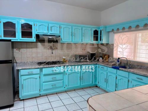 a blue kitchen with blue cabinets and appliances at Flores Condominios Casa Narciso in Álamos