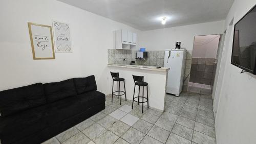 een woonkamer met een bank en een keuken bij Casa com Quarto e Garagem, Alto da Cruz, Camaçari in Camaçari