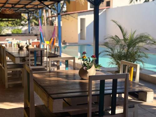 a wooden table with chairs and flowers on it next to a pool at Hotel Chuburna in Chuburná