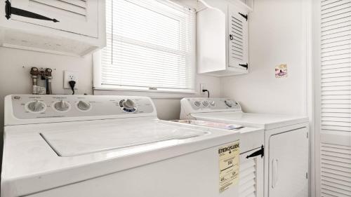 a white kitchen with a sink and a dishwasher at Lagoon Front 4 Bedroom Beat The Crowds in Beach Haven West