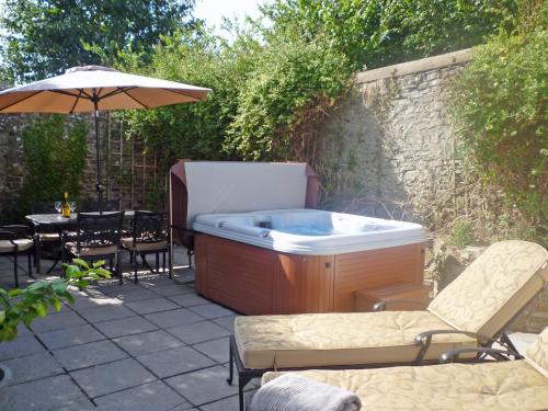 a hot tub in a backyard with a table and chairs at The Orangery in Bideford
