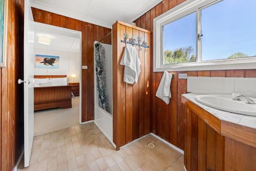 a bathroom with a tub and a sink and a window at Shelleys - Pet Friendly - Short Walk to Beach in Orient Point