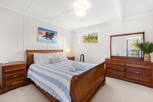 a bedroom with a bed and a dresser and a mirror at Shelleys - Pet Friendly - Short Walk to Beach in Orient Point