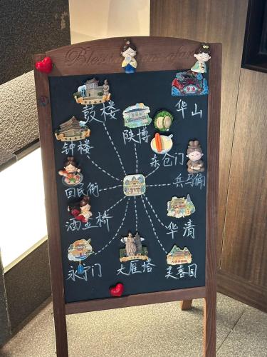 um quadro-negro com caracteres chineses em Xi'an MC City Courtyard Hotel - A st andalone hotel by the city wall - Close to the bell tower and yongning gate - Designed in song dynasty aesthetic style - It features private courtyard and garden rooms - Integrating the historical culture of Xi'an em Xian