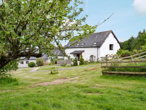 a white house in a field with a grass yard at Brameley in Cheriton Bishop