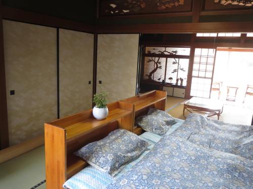 - une chambre avec 2 lits et une table dans l'établissement 日田グリーンツーリズム花の木, à Ueda