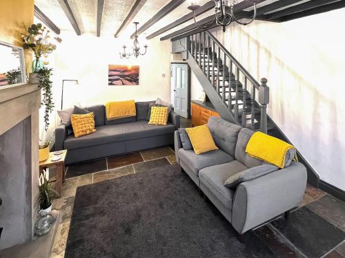 TrevorにあるMynydd A Mor, Mountains And Seaのソファ2つと階段のあるリビングルーム